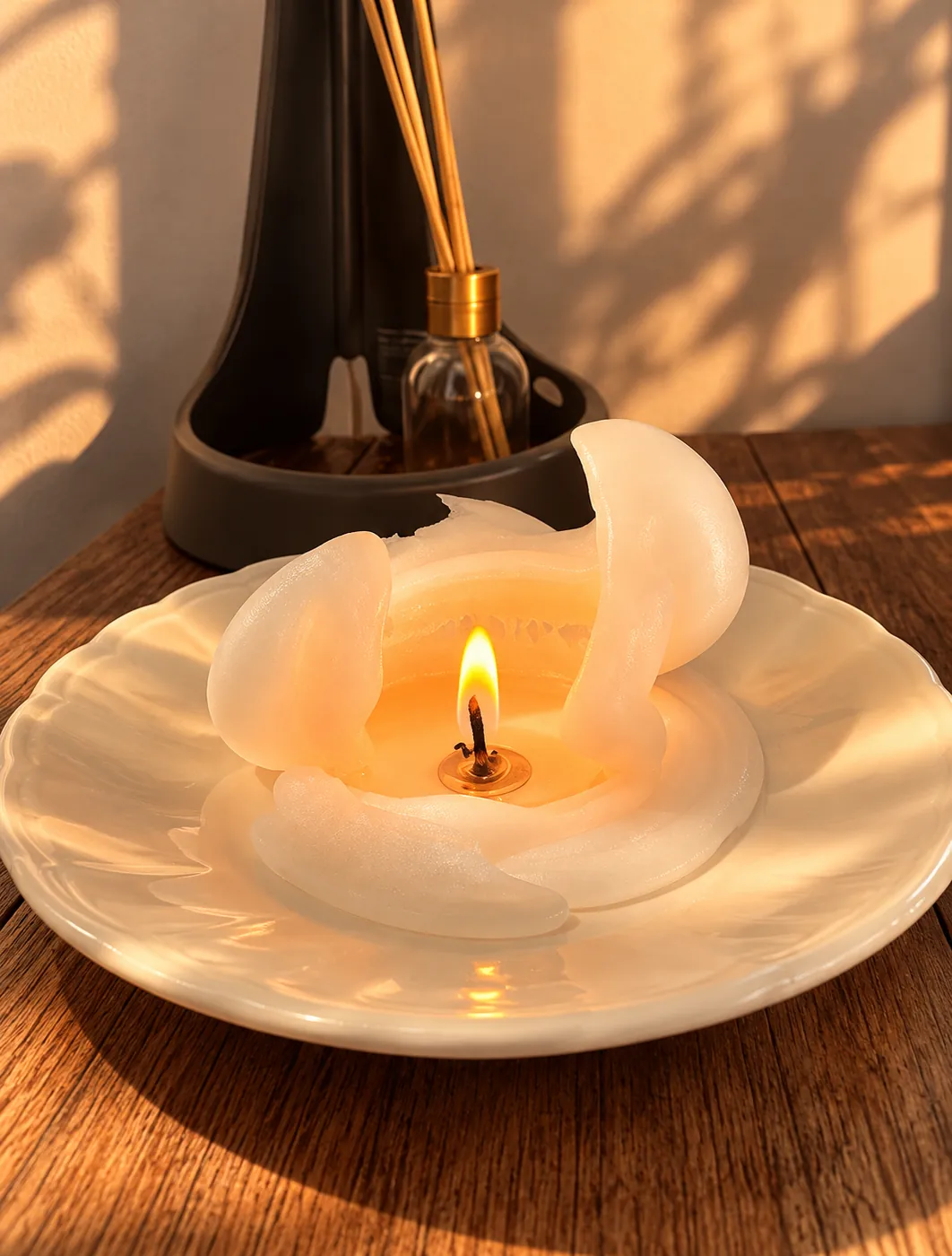 Vela de flor blanca encendida sobre un plato